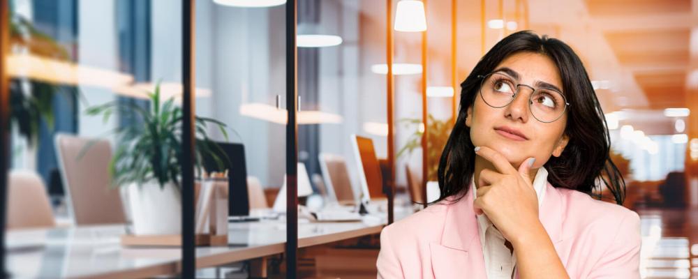 A woman thinks in an office about the e-liquids in her e-cigarette